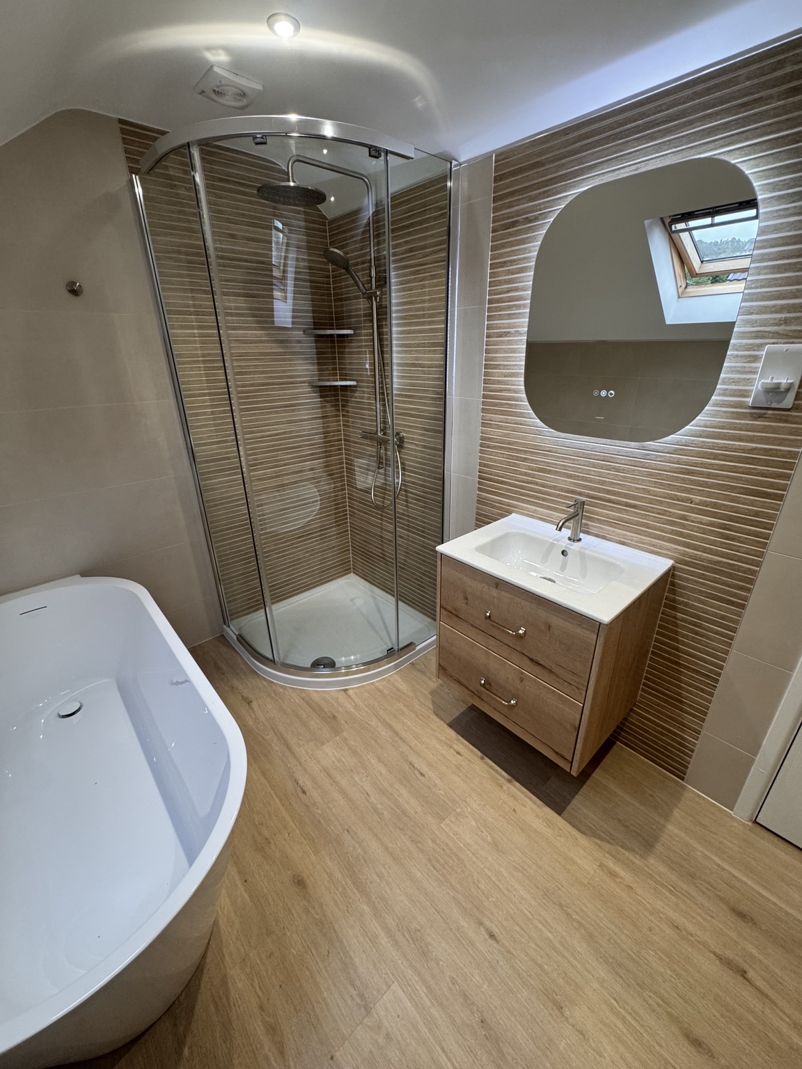 Bathroom with curved shower enclosure and wall-hung vanity