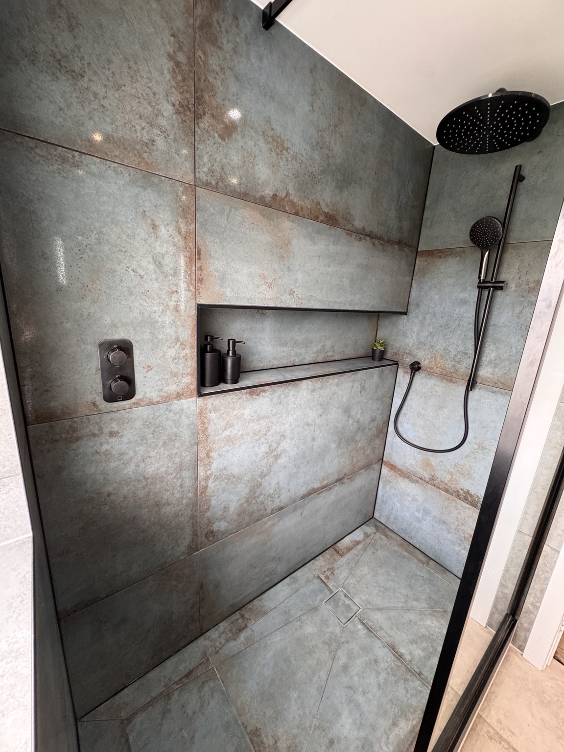 Feature wet room shower wall with recessed niche and black shower fittings
